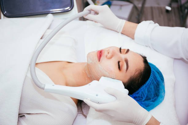 Young Asian woman getting IPL and laser treatment by beautician at beauty clinic