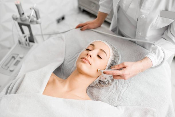 Young woman during the facial treatment procedure in the cosmetology office